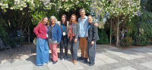 Seis participantes posan juntos en el jardín durante el V Congreso de Niñez, Educación y Salud Mental.
