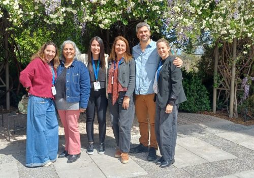 Seis participantes posan juntos en el jardín durante el V Congreso de Niñez, Educación y Salud Mental.
